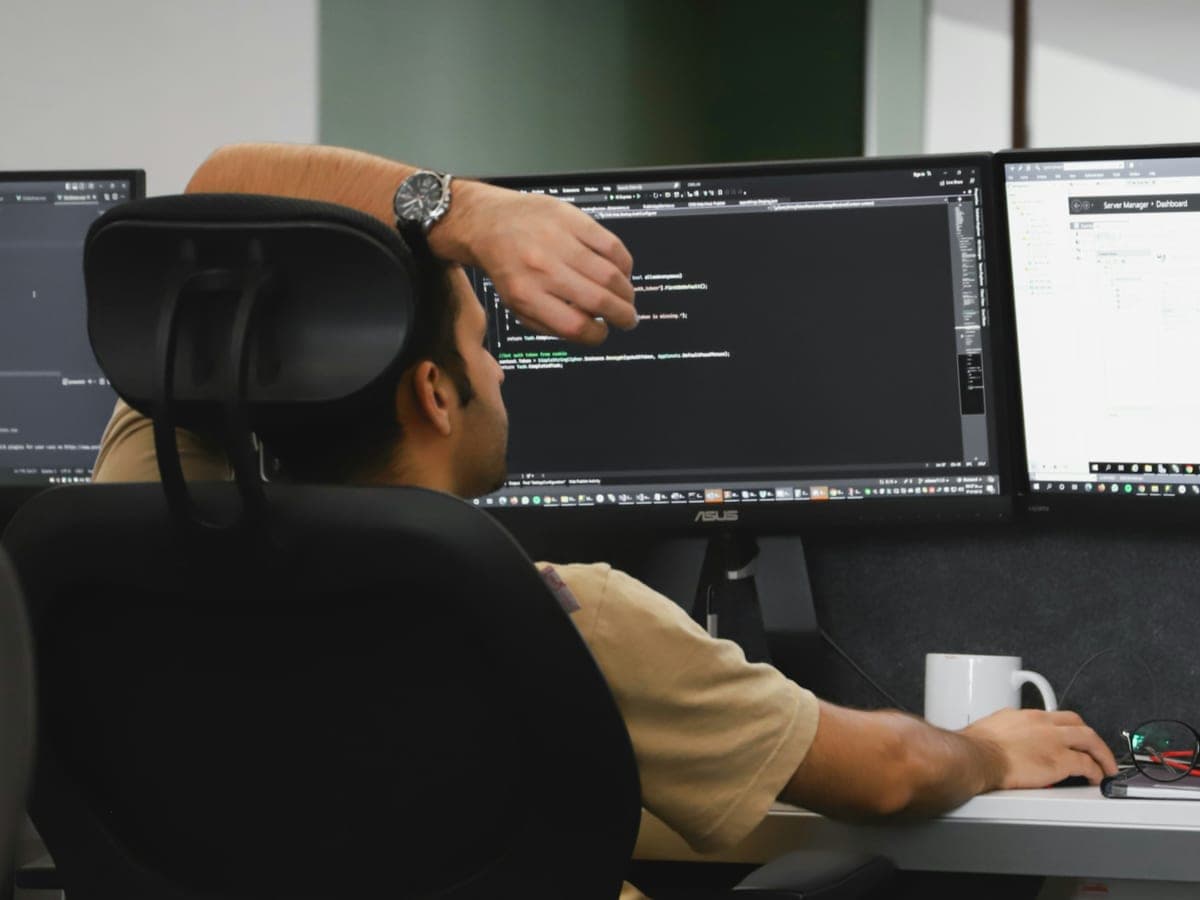 A developer working on application code across two screens